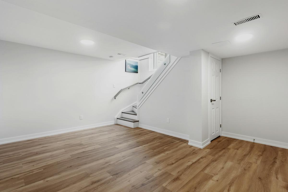 Finished basement living space with wood floors and stairs — the kind of lower level Cedar Rapids homeowners protect with radon testing and mitigation